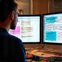Graphic designer working at computer with sample proofs